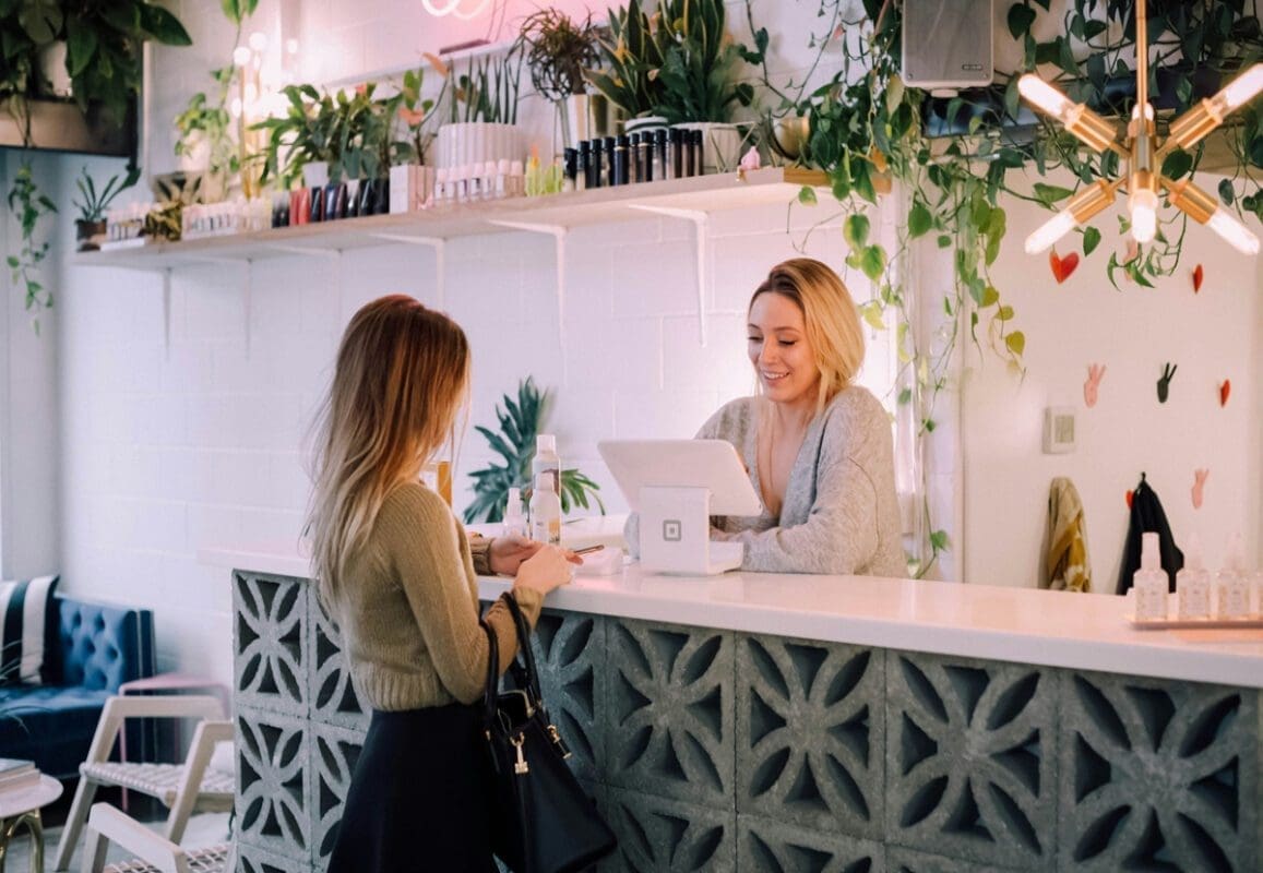 Two women across counter in tropic setting